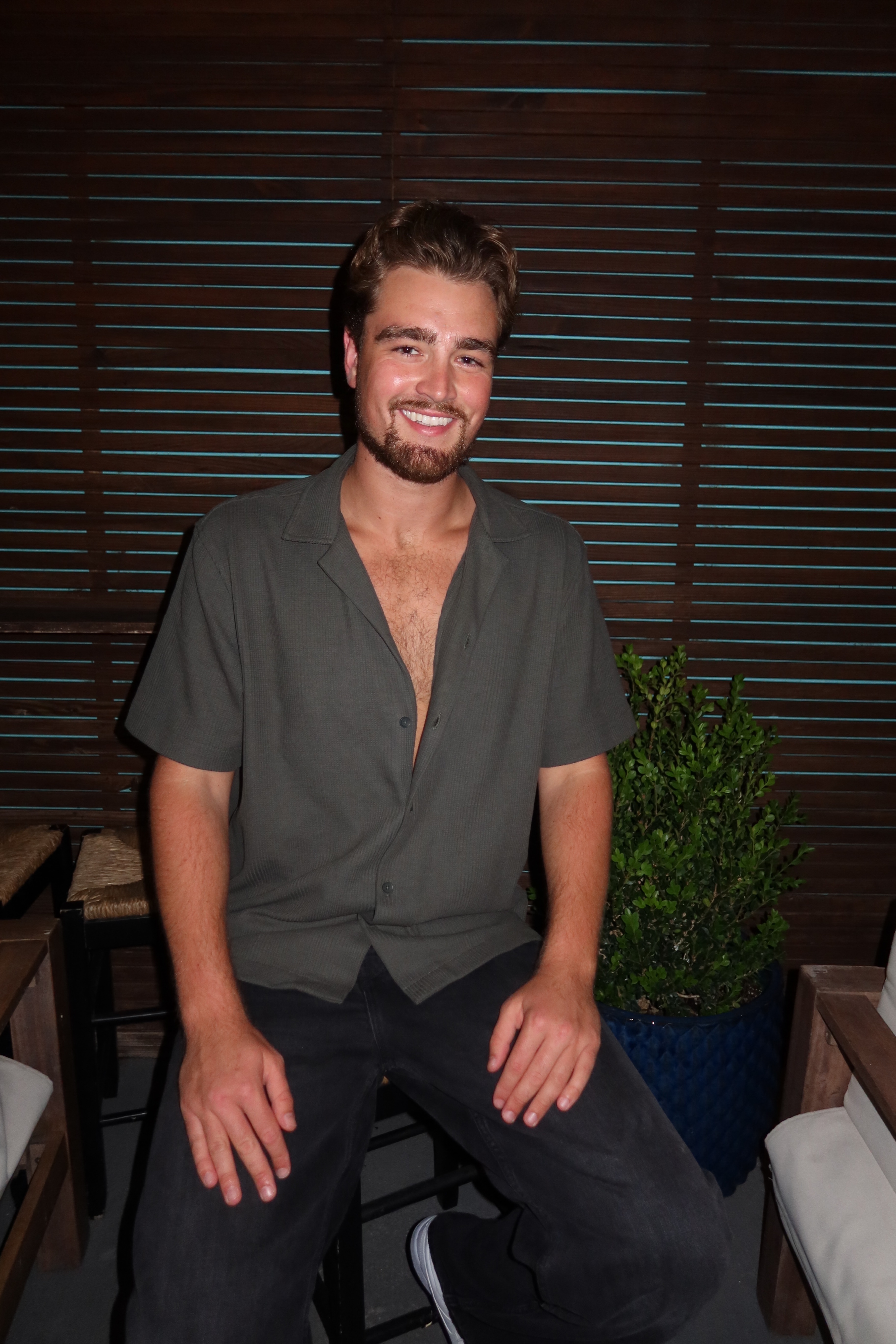 Shane, smiling, in a green camp shirt